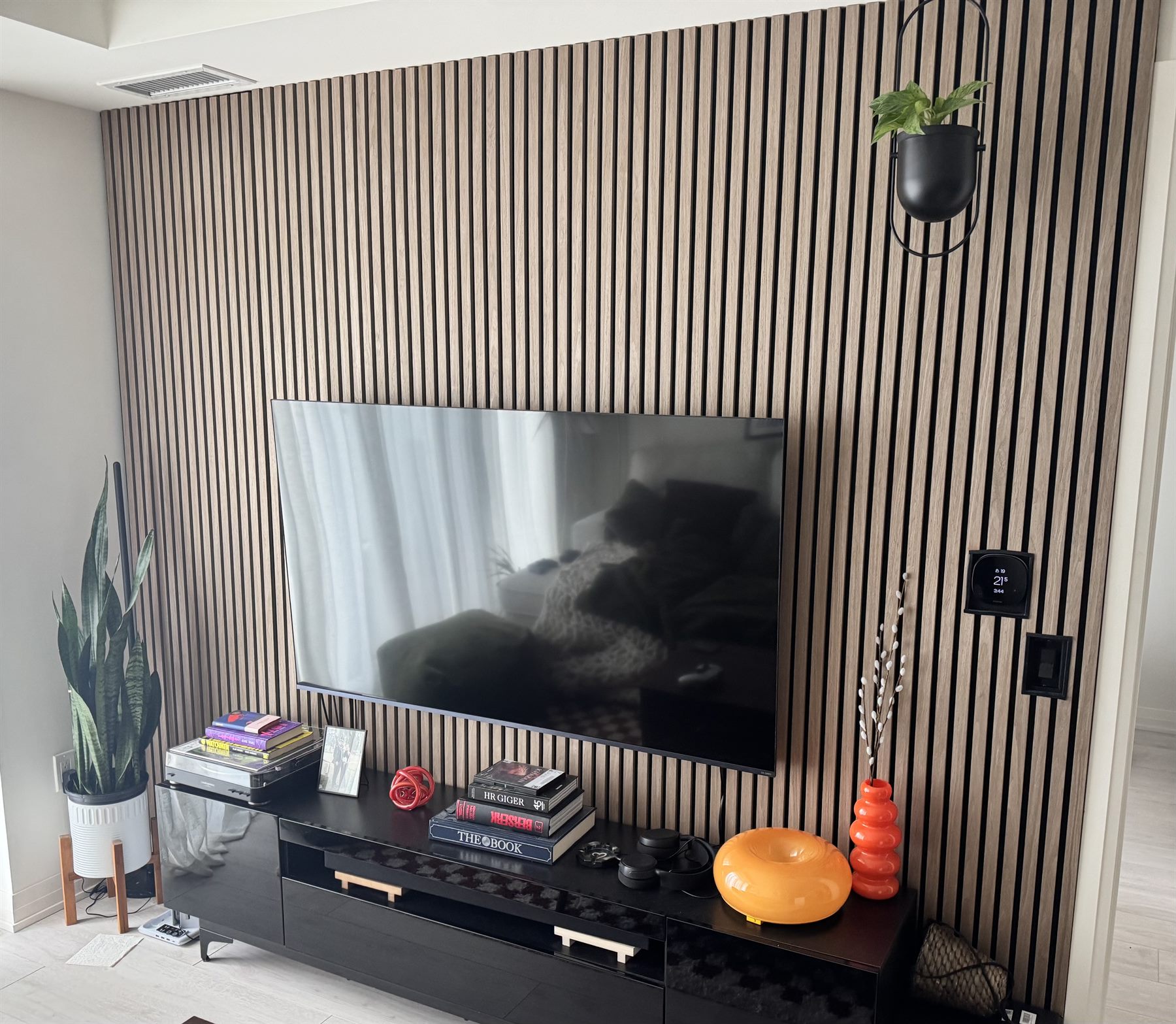 An oak slat feature wall photographed in daylight with the backlighting switched off.
